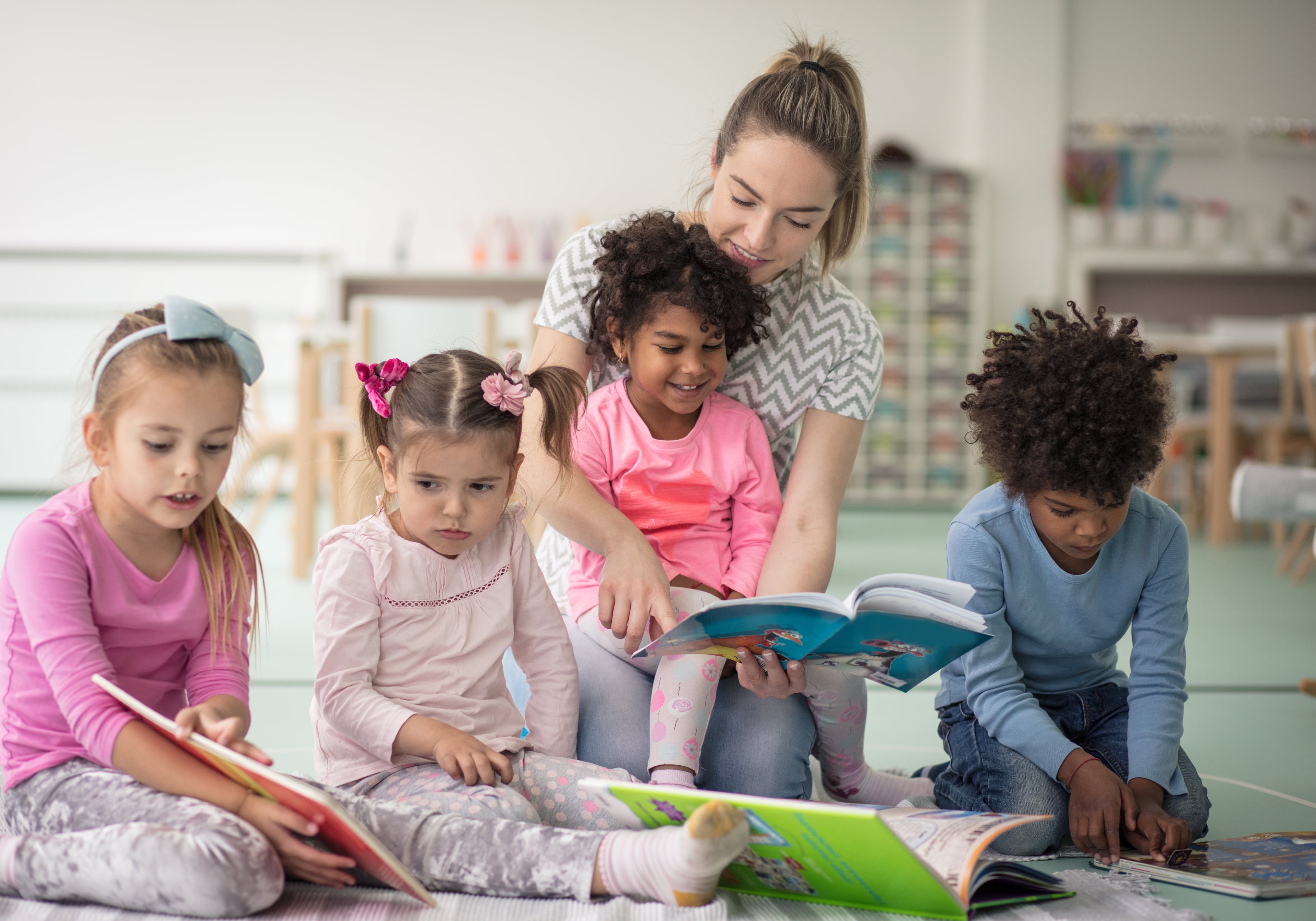 A daycare educator reading with children